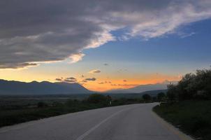 strada di campagna avventura con bellissimo tramonto foto