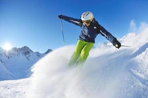 sciare sulla neve fresca nella stagione invernale in una bella giornata di sole foto