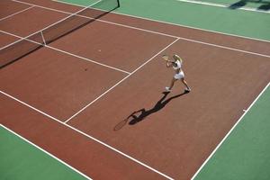 giovane donna giocare a tennis all'aperto foto