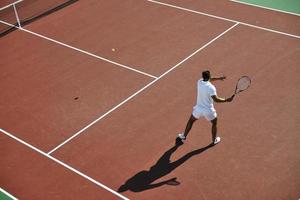 il giovane gioca a tennis foto