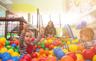 giovane mamma giocando con bambini nel piscina con colorato palle foto