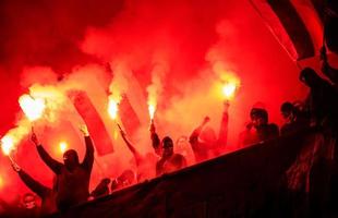 teppisti di calcio con maschera che tiene torce nel fuoco foto