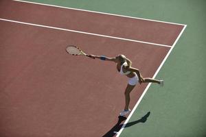 giovane donna giocare a tennis all'aperto foto