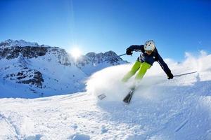 sciare sulla neve fresca nella stagione invernale in una bella giornata di sole foto