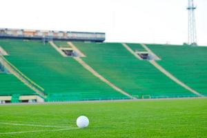 calcio palla su erba a obbiettivo e stadio nel sfondo foto