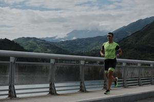 atleta di triathlon che corre su strada foto