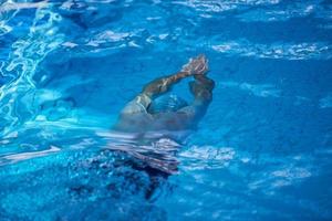 esercizio del nuotatore sulla piscina coperta foto