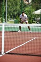 il giovane gioca a tennis all'aperto foto