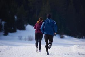 coppia jogging al di fuori su neve foto