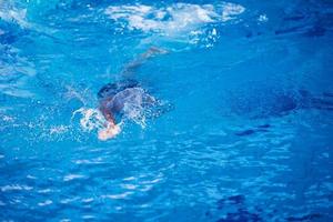 esercizio del nuotatore sulla piscina coperta foto