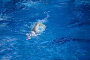 esercizio del nuotatore sulla piscina coperta foto