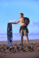 ritratto di un' giovane kitesurf uomo a spiaggia su tramonto foto