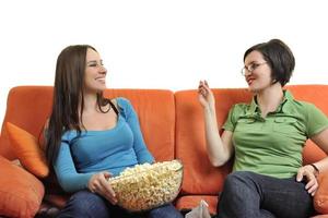 femmina amici mangiare Popcorn e Guardando tv a casa foto