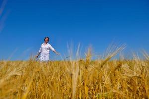 giovane donna nel campo di grano in estate foto