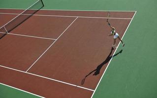 giovane donna giocare a tennis all'aperto foto