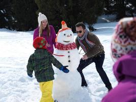 famiglia felice che fa pupazzo di neve foto