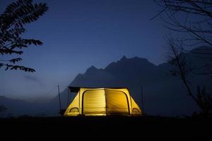 campo e tenda nel il notte nel davanti di il montagne con nube nel naturale parco, turismo concetto foto