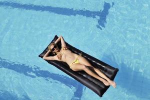 bellissimo donna rilassare su nuoto piscina foto