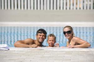 contento giovane famiglia avere divertimento su nuoto piscina foto