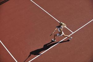 giovane donna giocare a tennis all'aperto foto