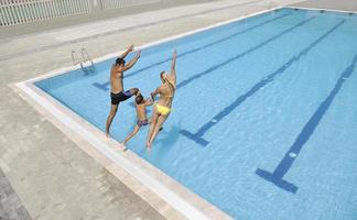 contento giovane famiglia avere divertimento su nuoto piscina foto