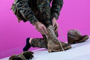 soldato legatura il lacci su il suo stivali foto