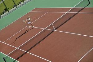 giovane donna giocare a tennis all'aperto foto