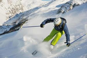 sciare sulla neve fresca nella stagione invernale in una bella giornata di sole foto