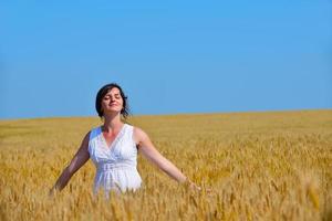 giovane donna nel campo di grano in estate foto