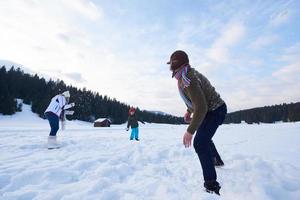 contento famiglia giocando insieme nel neve a inverno foto