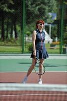 giovane donna giocare a tennis all'aperto foto