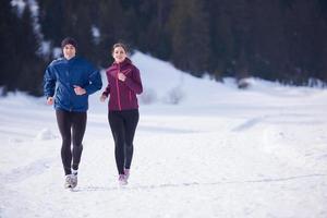 coppia jogging al di fuori su neve foto