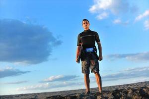 ritratto di un' giovane kitesurf uomo a spiaggia su tramonto foto