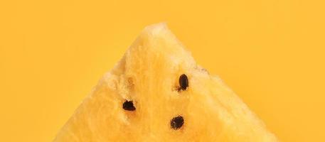 un pezzo di anguria gialla con semi su sfondo giallo, deliziosa frutta rinfrescante foto