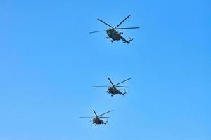 tre elicotteri militari che volano nel cielo blu eseguendo un volo dimostrativo, uno spettacolo aereo, uno spazio di copia foto