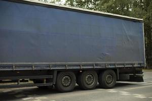 camion è guida giù autostrada. grande trailer su traccia. mezzi di trasporto di merce nel estate. tenda su corpo. foto