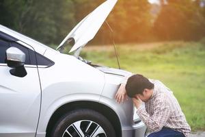 giovane uomo stressato che ha problemi con il suo stress rotto nella sala macchine dell'auto incidente al motore guasto in attesa di aiuto. foto