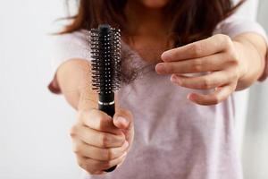 giovane donna preoccupato di capelli perdita problema dopo pettine nel mano. problema ormonale squilibrio, fatica concetto. Salute cura concetto foto