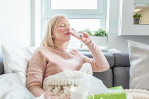 donna è avendo influenza e lei è utilizzando nasale spray per Aiuto se stessa. donna utilizzando nasale spray. nasale spray per Aiuto un' freddo. malato con un' rinite donna gocciolante naso. donna si applica nasale spray foto