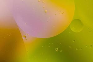 astratto goccioline olio bolle su il acqua colorato sfondo, macro fotografia olio bolle superficie foto