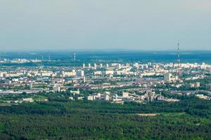 vista panoramica ariel della città e dei grattacieli con un'enorme fabbrica con camini fumanti sullo sfondo foto