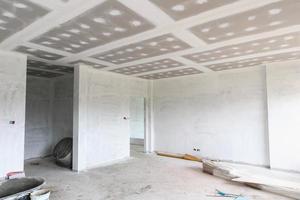 interno della stanza vuota con soffitto in cartongesso in cantiere foto