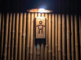 cartello di uomo di genere nel davanti di classico bambù Vintage ▾ e retrò gabinetto interno con luce bassa. foto