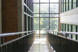 passerella in legno in pendenza nella biblioteca con la luce della finestra dall'esterno. foto