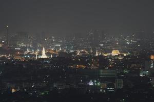 bangkok paesaggio urbano nel il mezzo di il cittadina, Tele tiro e vicino su per wat arun ratchawararam ratchawaramahawihan con notturno panorama Visualizza. foto