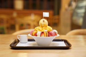 bingsu, asiatico Ghiaccio, fresco estate dolce con macron, fragola, mandorla e vaniglia ghiaccio crema. rasato e versato con zuccherato condensato latte foto