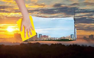 mano elimina giallo Alba al di sopra di città di stoffa foto