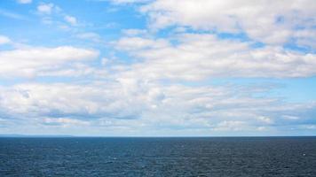 bianca nuvole nel blu cielo al di sopra di baltico mare nel autunno foto