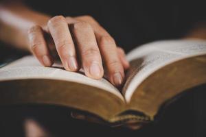 giovane donna persona mano Tenere santo Bibbia con studia a casa. adulto femmina cristiano lettura libro nel Chiesa. ragazza apprendimento religione spiritualità con pregare per Dio. concetto di alunno formazione scolastica fede. foto