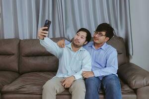 contento gay coppia assunzione un' autoscatto con mobile Telefono. foto